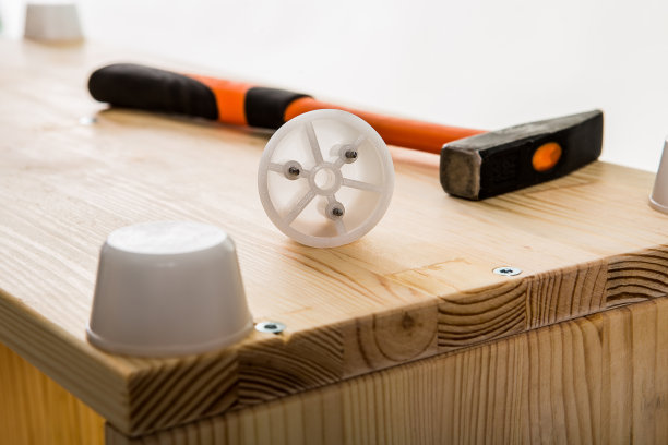 锤子和塑料家具细节上的木制模块。图片下载