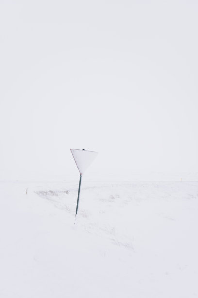 十字路口上被雪覆盖的路标让路图片下载