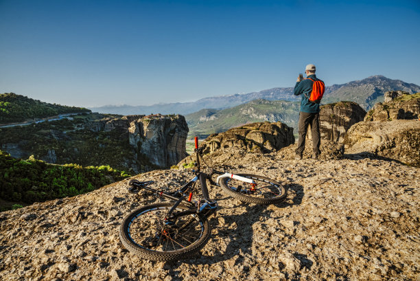 在欧洲山区背着背包和自行车的年轻人图片下载