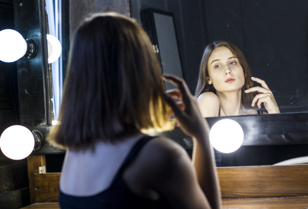 迷人的女孩在镜子里欣赏自己图片下载