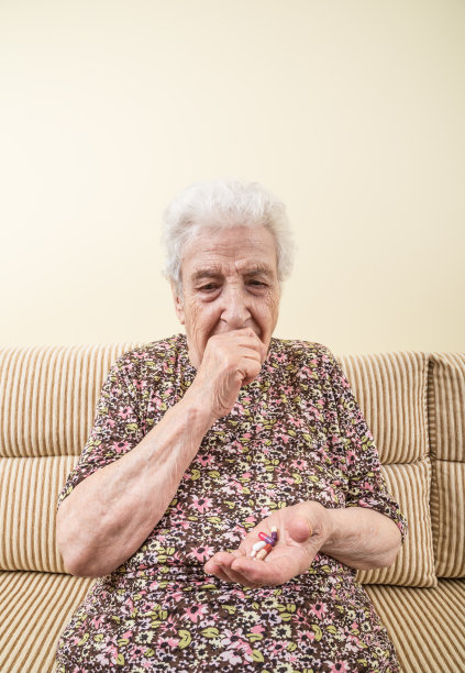 生病的年长妇女在吃药图片下载