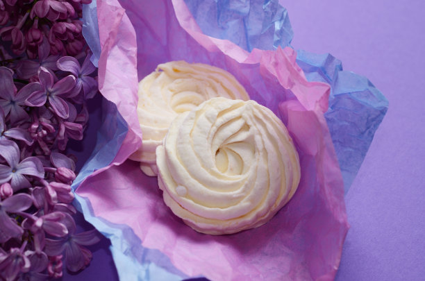 食物照片自制的和风，紫色包装纸棉花糖和咖啡外带杯。粉色背景上的甜点。图片下载