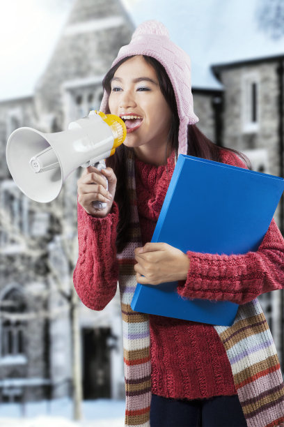 亚洲学生穿着冬装，用扩音器大喊图片下载