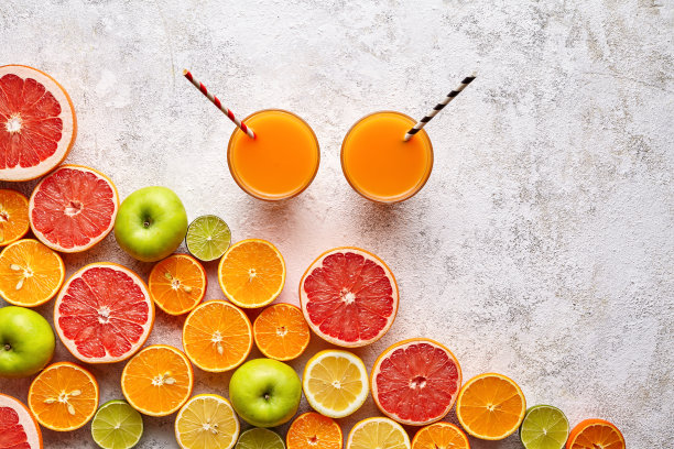 冰沙或新鲜果汁维生素c饮料在柑橘类水果的背景平lay，健康生活方式素食有机抗氧化排毒减肥饮料图片下载