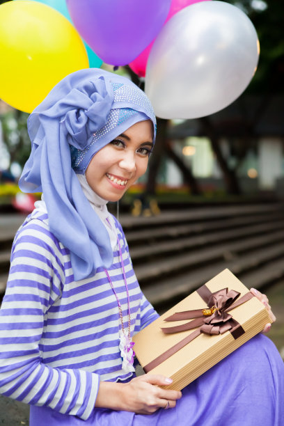 手持生日礼物微笑的穆斯林女性图片下载