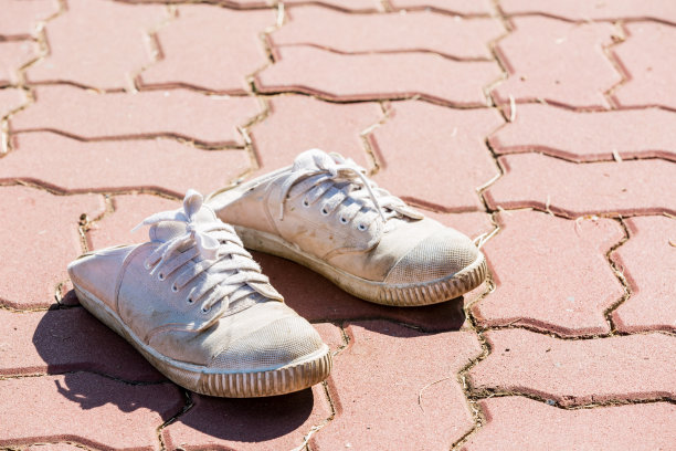 白色运动鞋放在砖地上图片下载