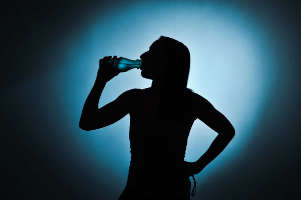 运动女孩喝水，剪影摄影棚拍摄图片下载