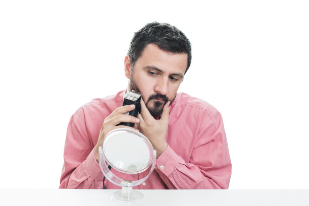 年轻人用电动剃须刀刮胡子图片下载