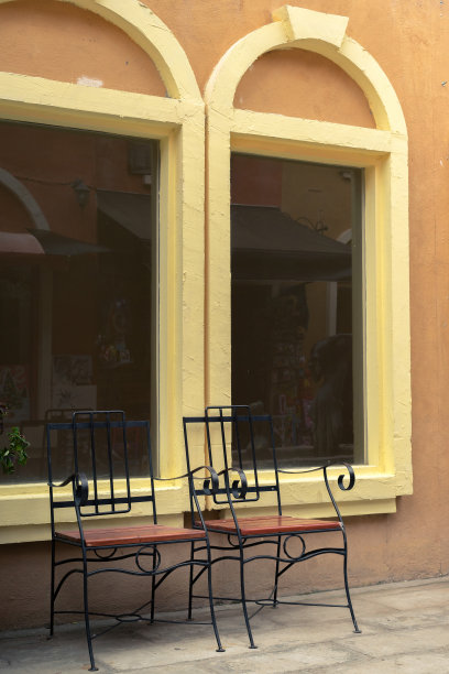 靠在黄色拱形窗户上的钢椅图片下载