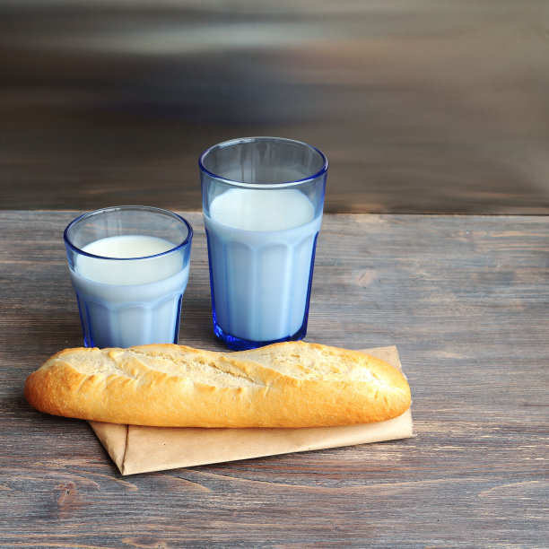 两杯不同大小的蓝色牛奶和法国面包图片下载