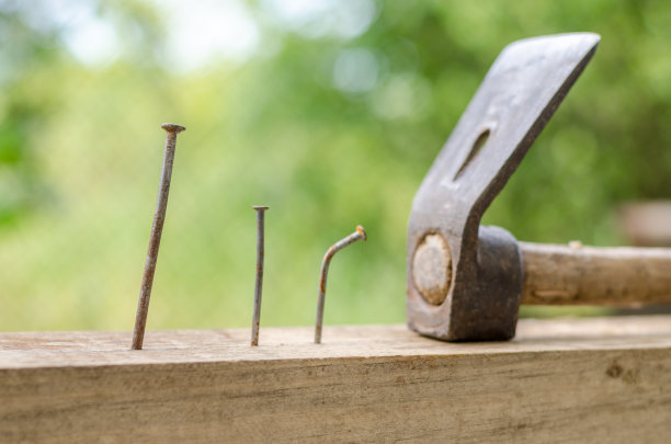 以铁锤、钉子、弯钉为背景，以木为底图片下载