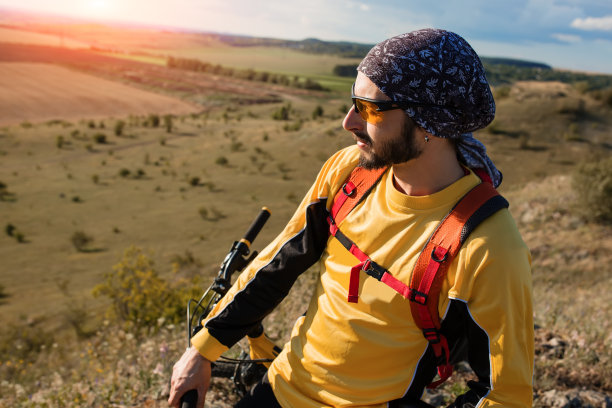 骑山地自行车的人骑在日落山谷的单轨上图片下载