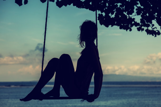 在海边荡秋千的女孩。图片下载