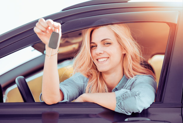 年轻开朗的女人拿着她第一辆新车的钥匙素材图片