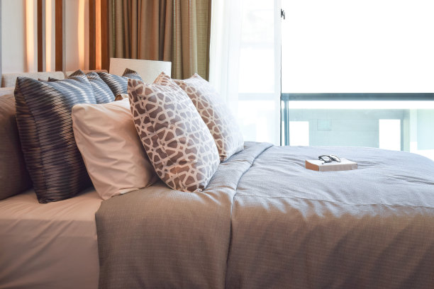 时尚的卧室室内设计，棕色的枕头和床上的书图片下载