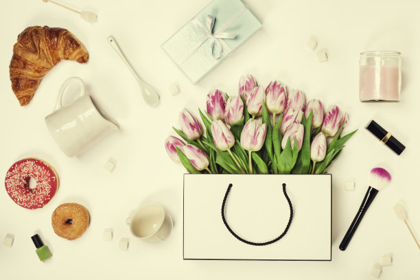 俯视图的春天鲜花，咖啡，手机，羊角面包，礼品和化妆品图片下载