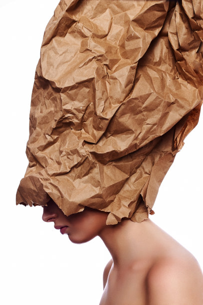 美容模特与皱巴巴的棕色纸在头上图片下载