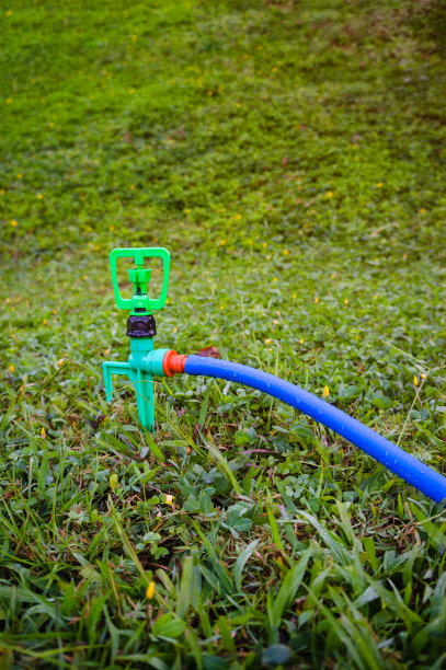园艺。草坪自动洒水器在绿色草地上。户外。图片下载
