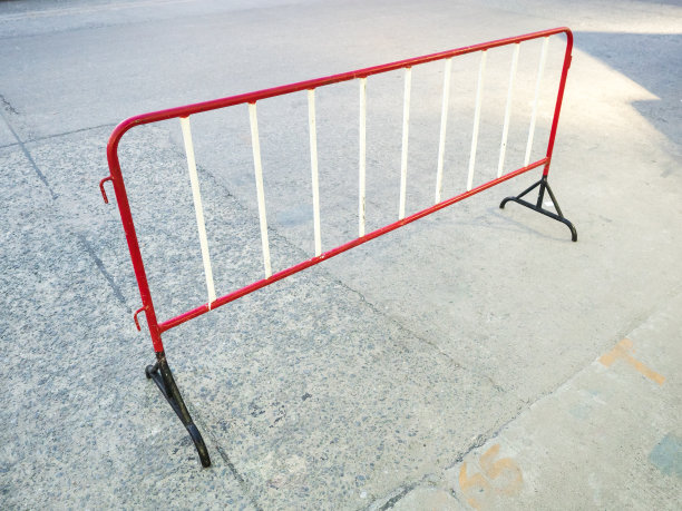 混凝土道路上临时的红黑钢移动围栏图片下载