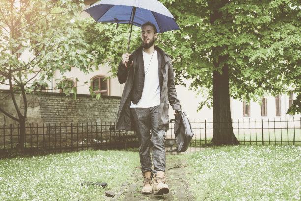 一个商人在雨季在公园里的肖像。图片下载