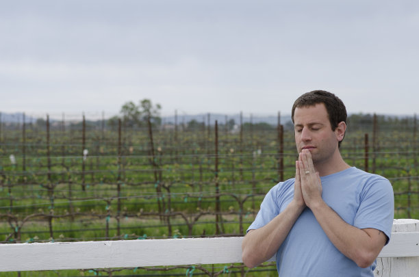 一个人在农田前独自祈祷。图片下载