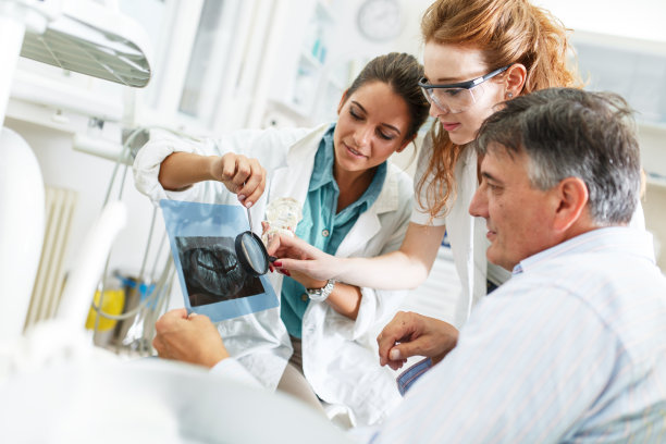 牙科医生和她的女助手在牙科诊所图片下载