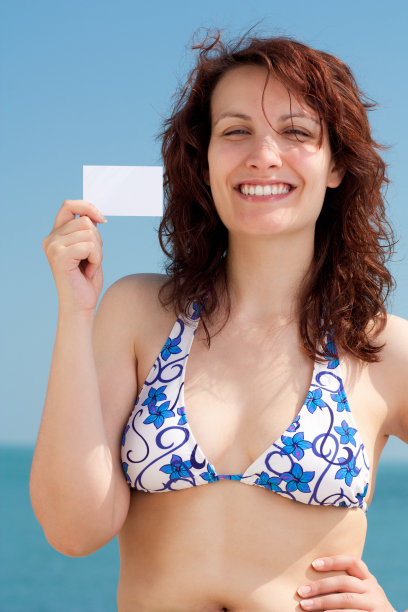 在海滩上拿着名片的女人图片下载