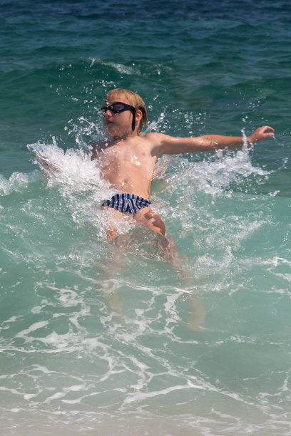 孩子在海浪上仰泳图片下载