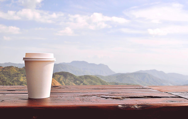 白色杯子里的咖啡，背后是自然风景。图片下载