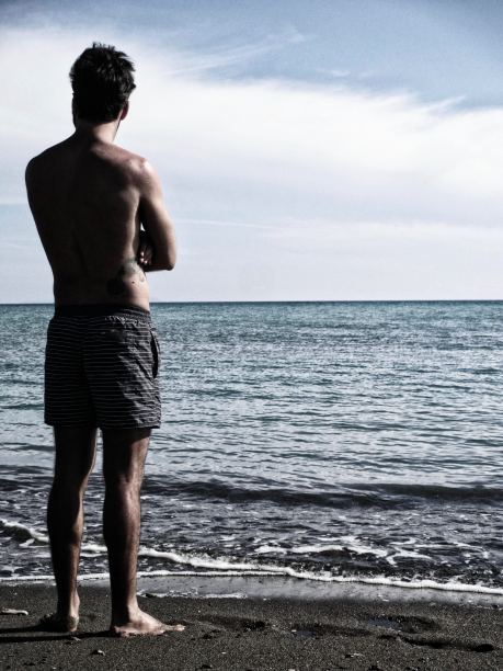 海滩上英俊的年轻人图片下载