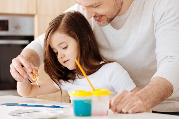 父亲轻轻地握着女儿的手拿着刷子图片下载