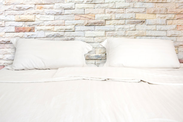 房间里有一张白色的床和两个枕头。图片下载