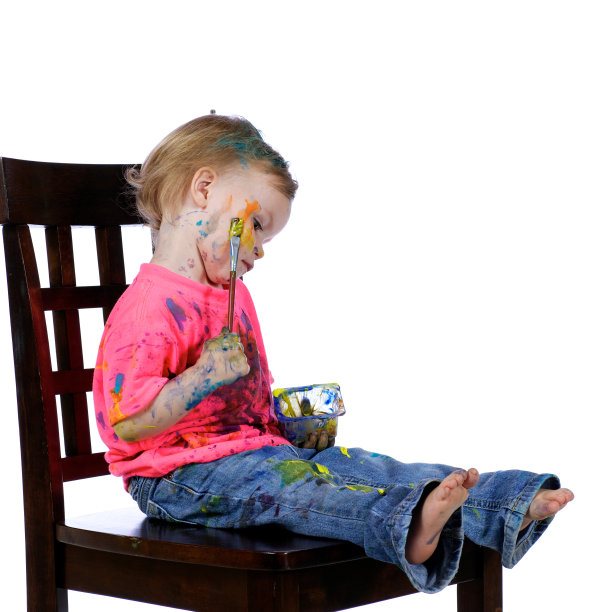 蹒跚学步的孩子有乐趣坐绘画自己。图片下载