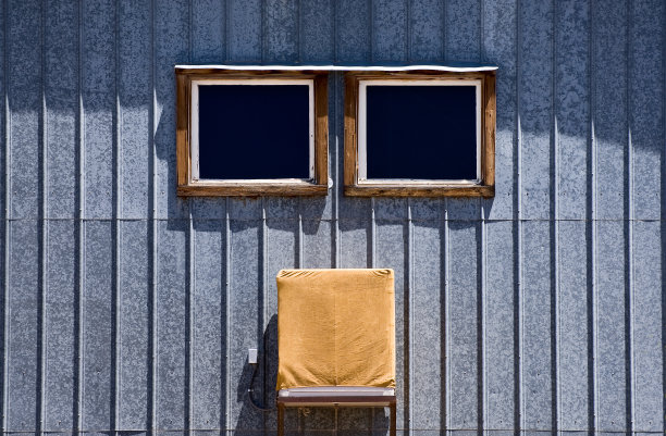 金属墙，两扇窗户，和一个有盖的空调图片下载