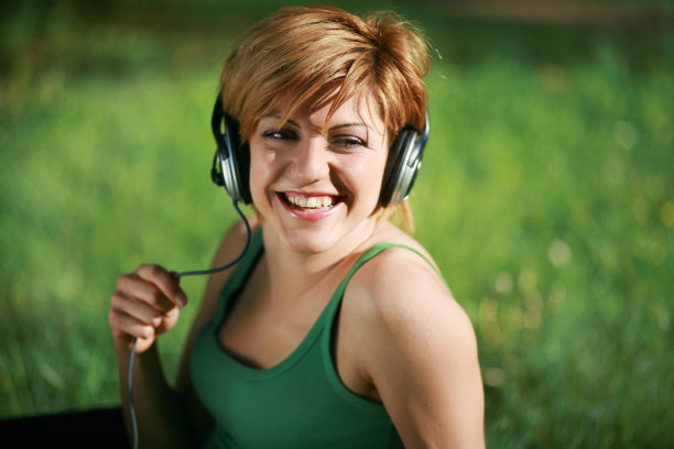 微笑的女孩戴着耳机听音乐图片下载