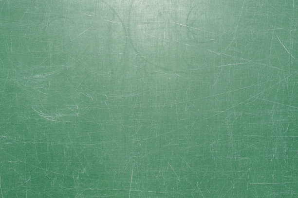 绿色黑板表面的纹理上覆盖着许多用粉笔写字留下的划痕图片下载