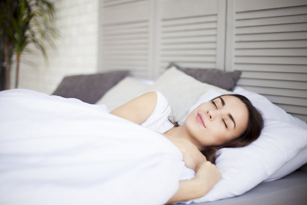 在阳光明媚的早晨躺在或睡在卧室里的女人素材图片