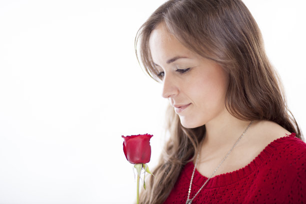 一个手持红玫瑰的漂亮女人的肖像图片下载