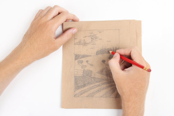 男人用手在牛皮纸上画风景画图片下载