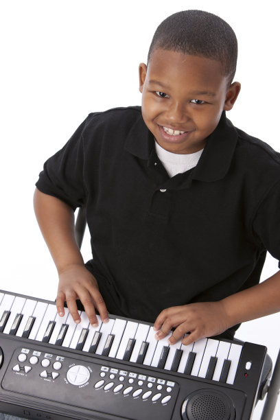 真人:非裔美国男孩弹奏风琴钢琴键盘图片下载