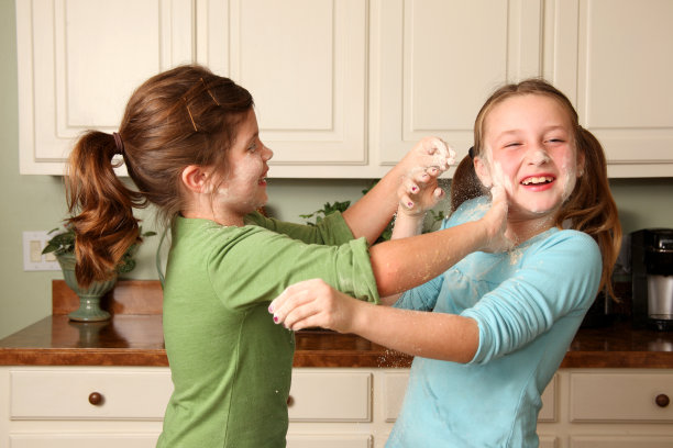 两个女孩在饼干面粉里玩图片下载
