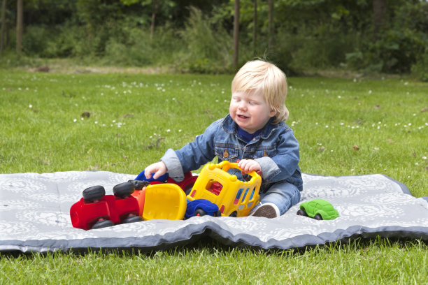 婴儿在后院的毯子上玩耍图片下载