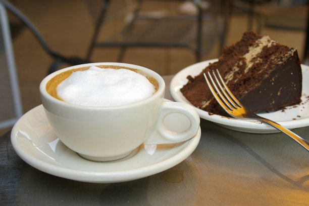 卡布奇诺，旁边是一块巧克力蛋糕图片下载