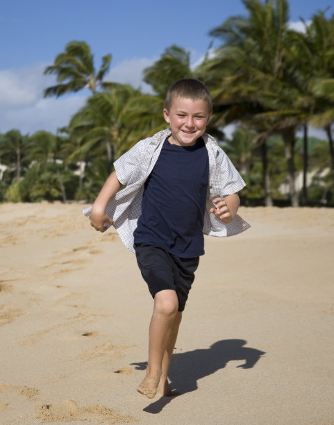 男孩在海滩上跑步图片下载