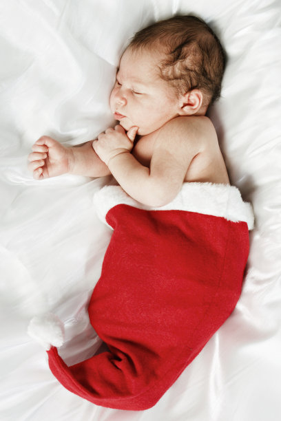 新生儿睡在圣诞老人的帽子里图片下载