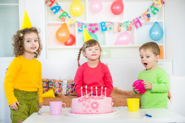 孩子们吹灭生日蛋糕上的蜡烛图片下载