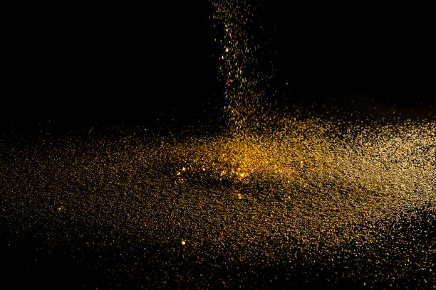 在有拷贝空间的黑色背景上撒上金粉。图片下载