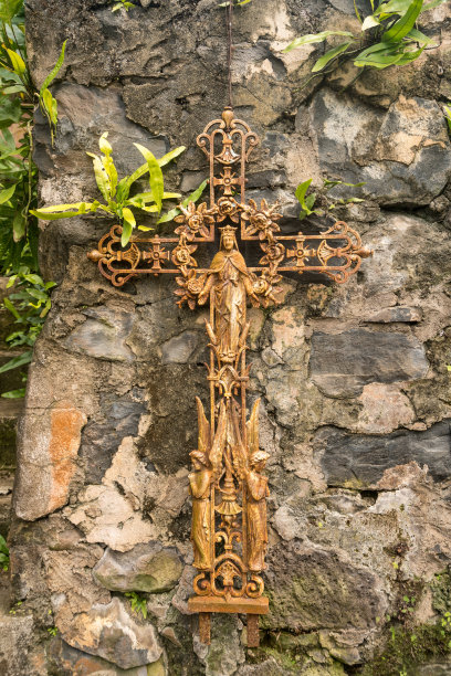 固定在旧石墙上的旧生锈耶稣受难像素材图片