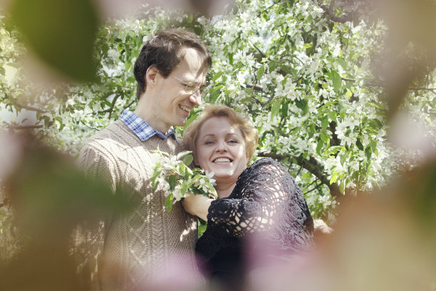 快乐的中年夫妇在苹果树花园里图片下载