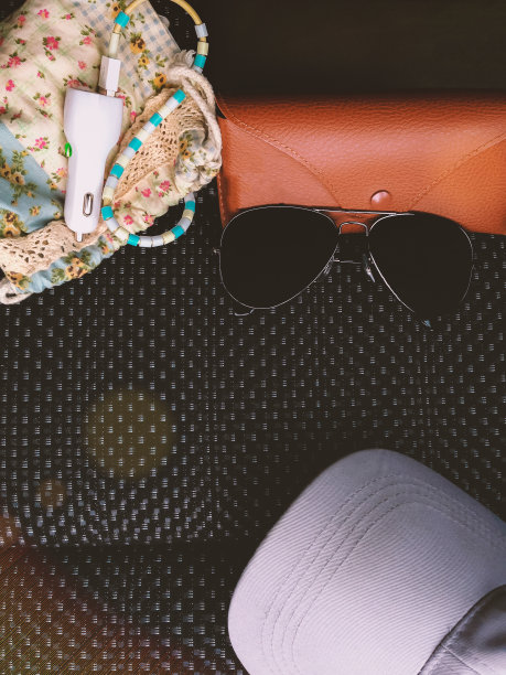 俯视图的旅行者的配件上的黑色座位，黑色太阳镜，案件和手机与副本空间的背景素材图片